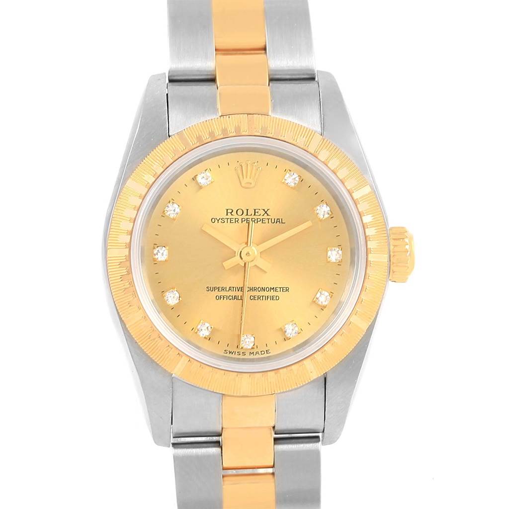 This Rolex Oyster Perpetual 76243 Women's Steel and Gold (two tone) Champagne Dial 76243 Women's Steel and Gold (two tone) Champagne Dial watch is shown from a top-down angle, highlighting its gold dial, bezel, and two-tone bracelet.
