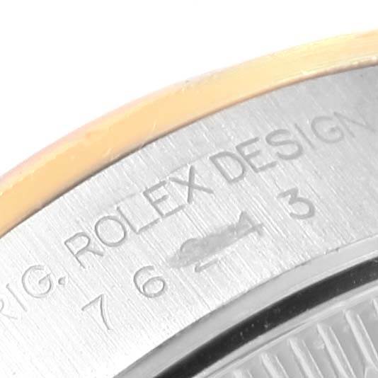 The image shows a close-up of the back casing of a Rolex Oyster Perpetual 76243 Women's Steel and Gold (two tone) Champagne Dial 76243 Women's Steel and Gold (two tone) Champagne Dial watch, featuring the engraved text "ROLEX DESIGN."