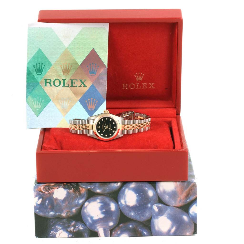 The image shows a Rolex Oyster Perpetual 76183 Women's Steel and Gold (two tone) Black Dial 76183 Women's Steel and Gold (two tone) Black Dial watch displayed in its open box with a booklet beside it.