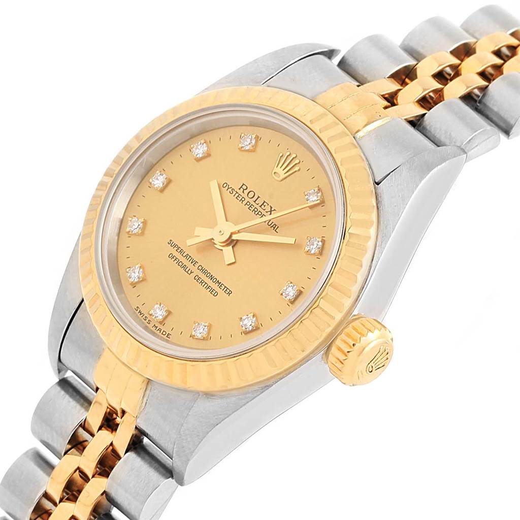 The Rolex Oyster Perpetual 67193 Women's Steel and Gold (two tone) Champagne Dial 67193 Women's Steel and Gold (two tone) Champagne Dial watch is shown at an angled view, displaying its gold bezel, crown, and part of the bracelet.