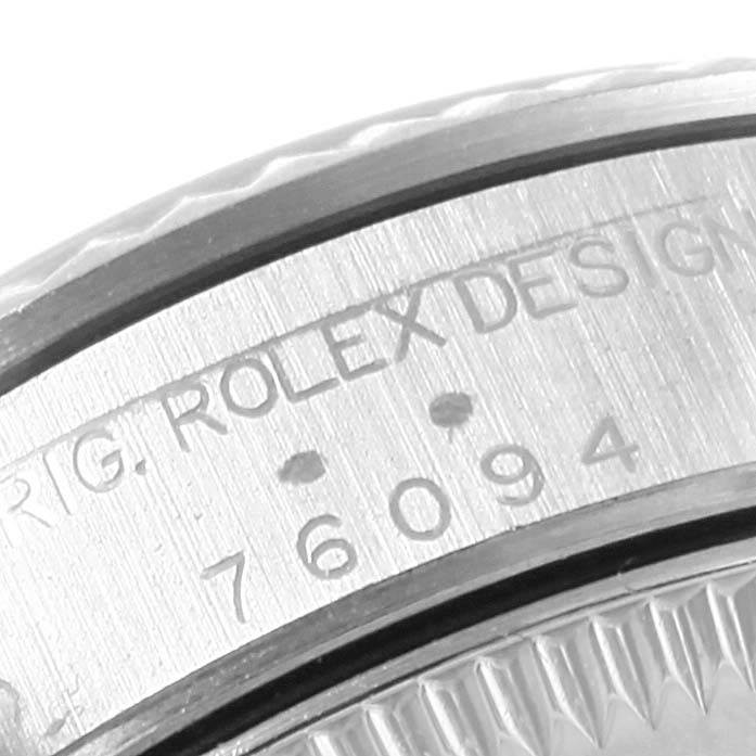 The image shows a close-up of the side detailing and engravings on the bezel of a Rolex Oyster Perpetual 76094 Women's Stainless Steel Black Dial 76094 Women's Stainless Steel Black Dial watch.