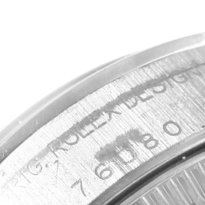 This close-up image shows the engraved side of the bezel on a Rolex Oyster Perpetual 76080 Women
s Stainless Steel Pink Dial 76080 Women
s Stainless Steel Pink Dial watch, revealing part of its serial number.