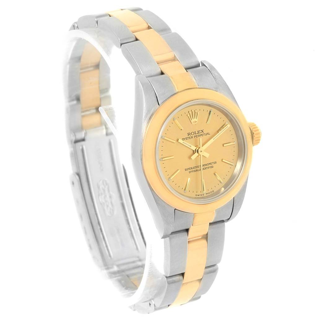 The image shows a Rolex Oyster Perpetual 76183 Women
s Steel and Gold (two tone) Champagne Dial 76183 Women
s Steel and Gold (two tone) Champagne Dial watch at an angled side view, highlighting its two-tone bracelet and gold dial.
