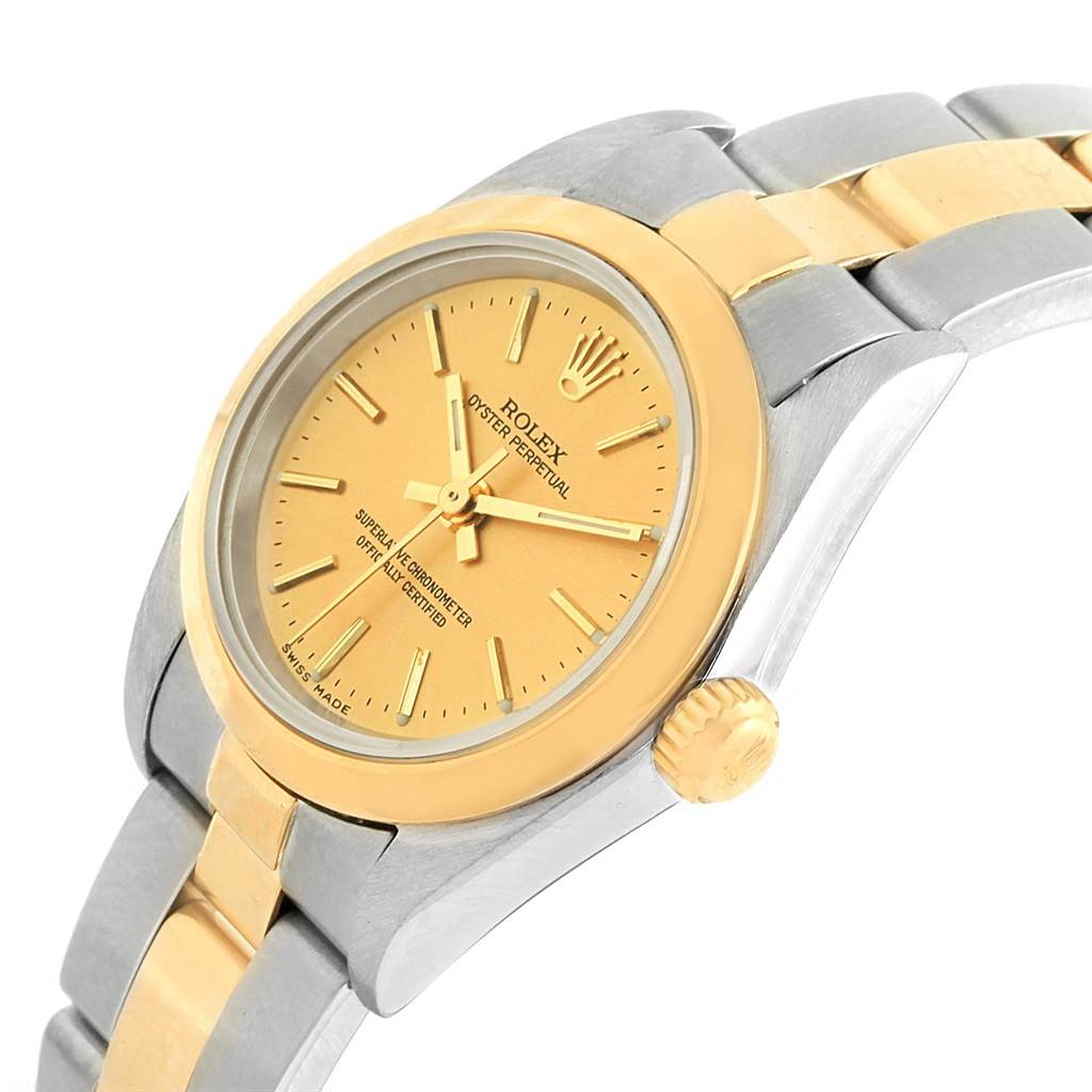 The image shows a close-up angle of a Rolex Oyster Perpetual 76183 Women
s Steel and Gold (two tone) Champagne Dial 76183 Women
s Steel and Gold (two tone) Champagne Dial watch, highlighting the dial, bezel, and part of the bracelet.