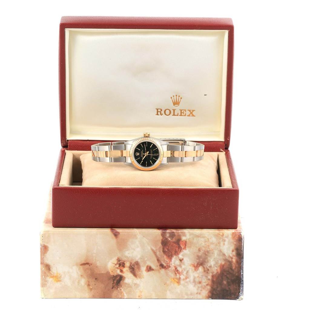 The Rolex Oyster Perpetual 67193 Women's Steel and Gold (two tone) Black Dial 67193 Women's Steel and Gold (two tone) Black Dial watch is shown from the front within its branded open box.