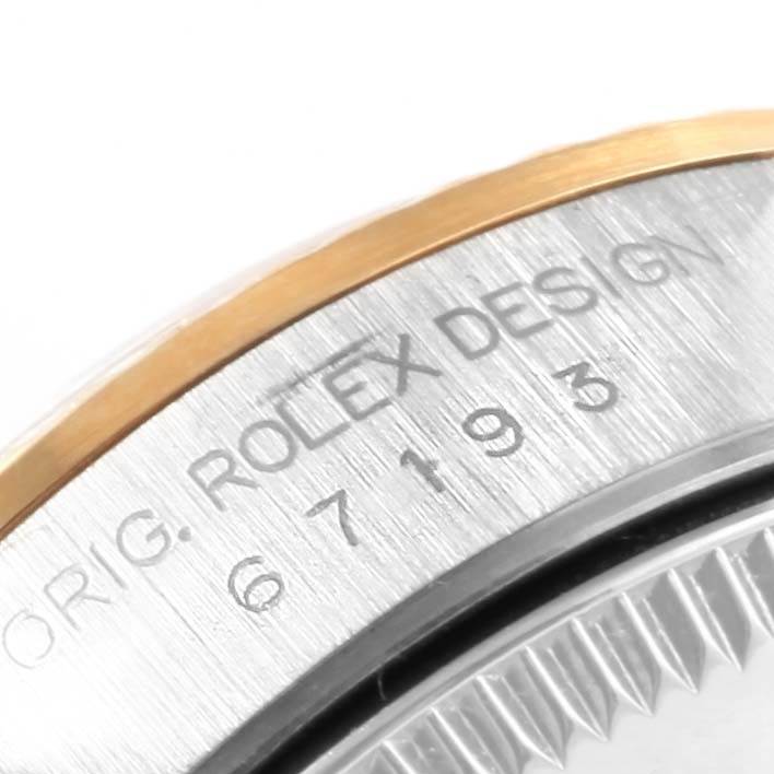 The image shows a close-up of the side of a Rolex Oyster Perpetual 67193 Women's Steel and Gold (two tone) Black Dial 67193 Women's Steel and Gold (two tone) Black Dial, highlighting the model number and "Rolex Design" engraving.