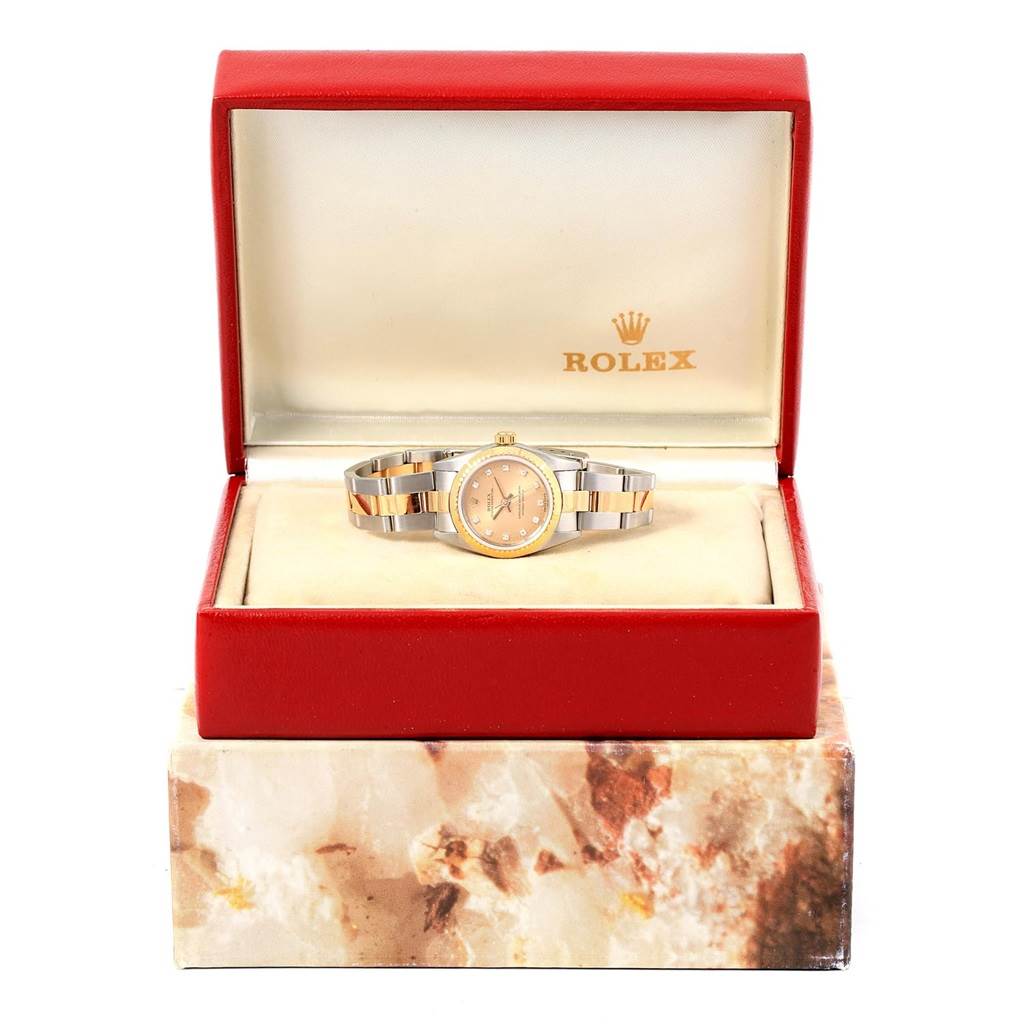 A Rolex Oyster Perpetual 76243 Women's Steel and Gold (two tone) Champagne Dial 76243 Women's Steel and Gold (two tone) Champagne Dial watch is displayed in an open red box, showcasing its face and bracelet from the front.