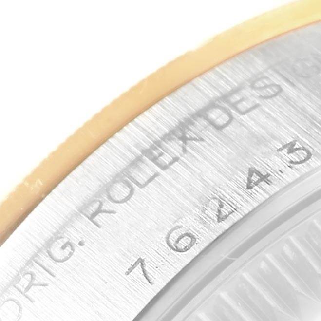 This close-up image shows the side of the bezel of a Rolex Oyster Perpetual 76243 Women's Steel and Gold (two tone) Champagne Dial 76243 Women's Steel and Gold (two tone) Champagne Dial watch, featuring engravings on the metal surface.