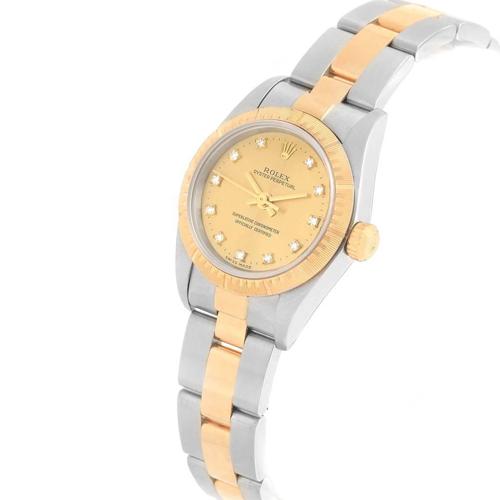 The image shows a Rolex Oyster Perpetual 76243 Women's Steel and Gold (two tone) Champagne Dial 76243 Women's Steel and Gold (two tone) Champagne Dial watch at an angled view, highlighting its two-tone gold and silver band and bezel.