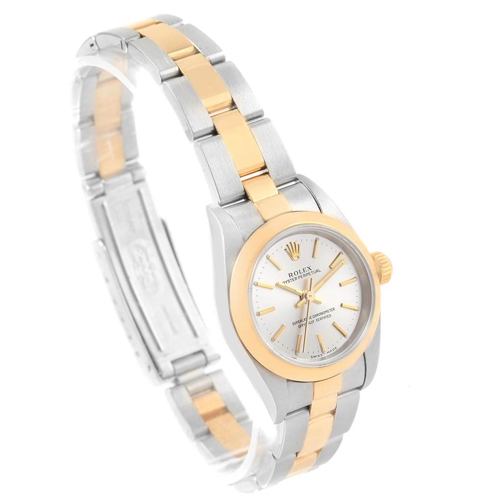 This Rolex Oyster Perpetual 76183 Women's Steel and Gold (two tone) Silver Dial 76183 Women's Steel and Gold (two tone) Silver Dial watch is shown at an angle highlighting the face, bezel, and two-tone bracelet.