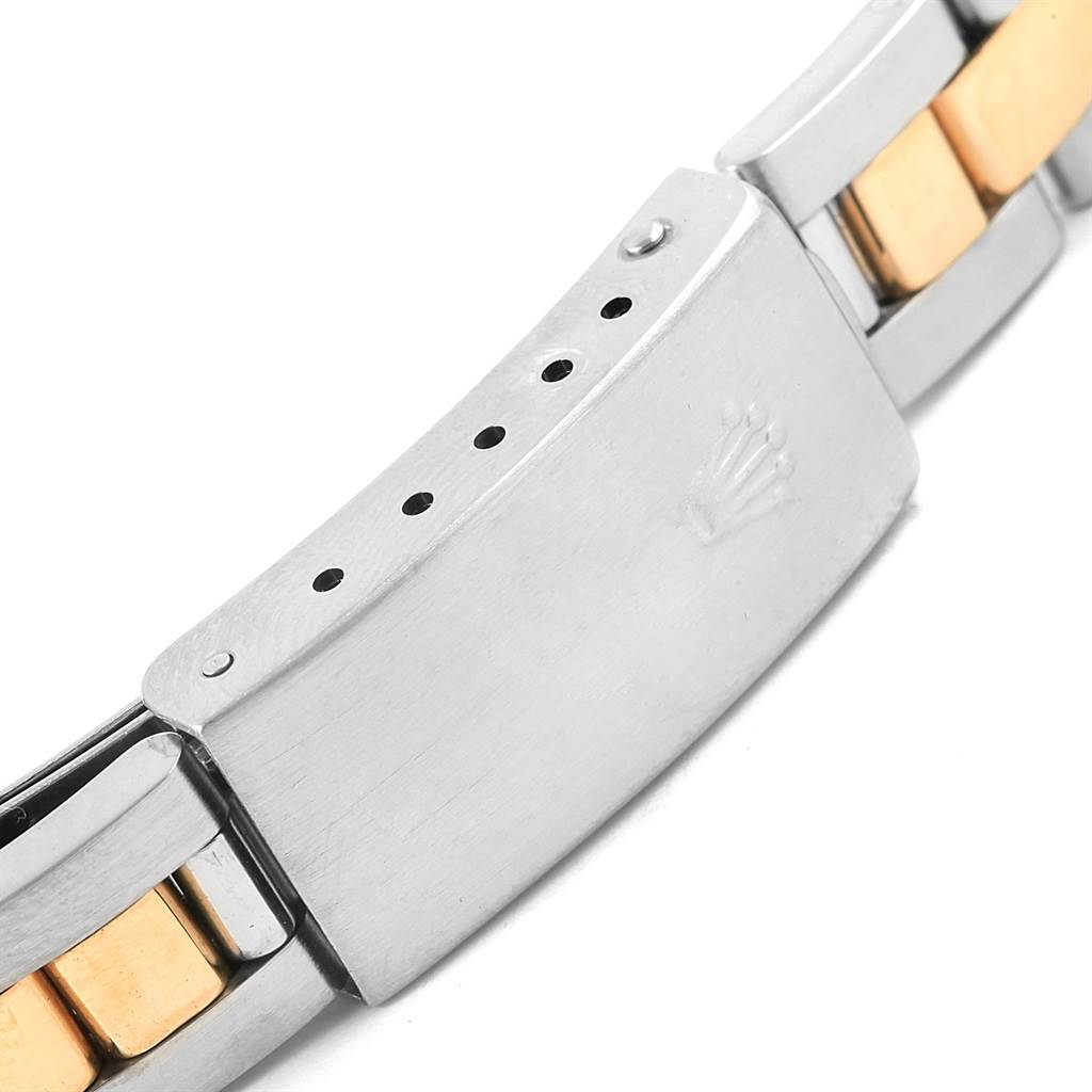 The image shows a close-up shot of the clasp of the Rolex Oyster Perpetual 76243 Women's Steel and Gold (two tone) Champagne Dial 76243 Women's Steel and Gold (two tone) Champagne Dial watch, highlighting the emblem and bracelet links.
