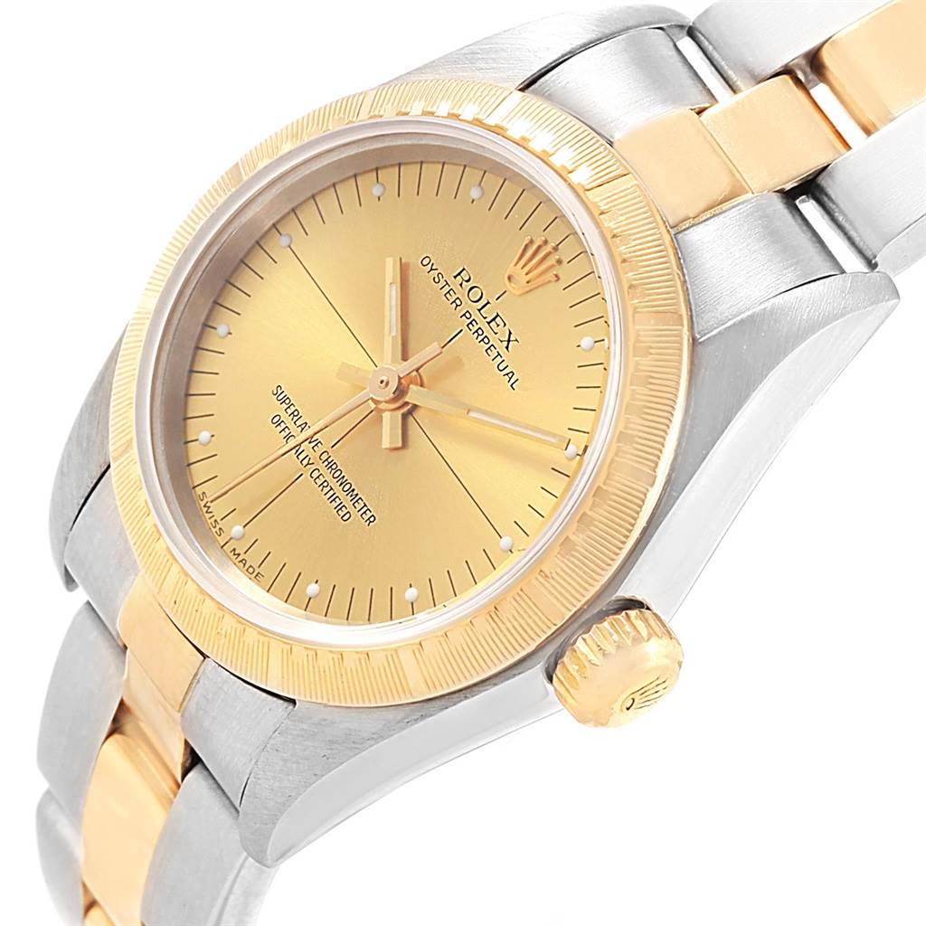 The Rolex Oyster Perpetual 76243 Women's Steel and Gold (two tone) Champagne Dial 76243 Women's Steel and Gold (two tone) Champagne Dial watch is shown at a slight angle, highlighting the dial, bezel, crown, and part of the bracelet.