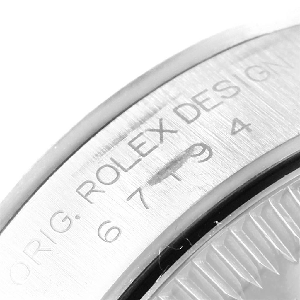 This close-up shows a portion of the bezel and engraving on the case of a Rolex Oyster Perpetual 67194 Women's Stainless Steel Pink Dial 67194 Women's Stainless Steel Pink Dial watch.