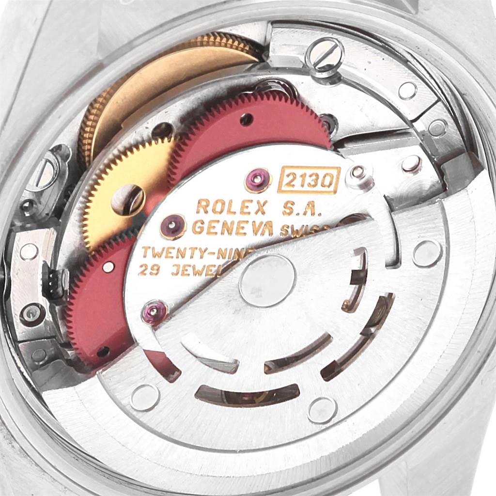 This image shows an inside view of the Oyster Perpetual Rolex watch, focusing on its caliber 2130 movement and gears.