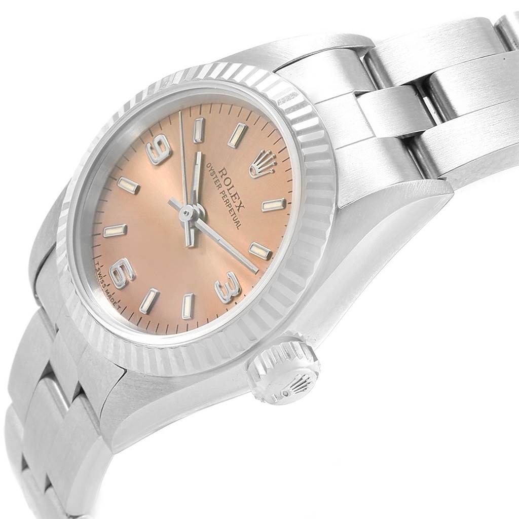 The image shows an angled side view of a Rolex Oyster Perpetual 67194 Women's Stainless Steel Pink Dial 67194 Women's Stainless Steel Pink Dial watch, featuring its dial, crown, and part of the bracelet.