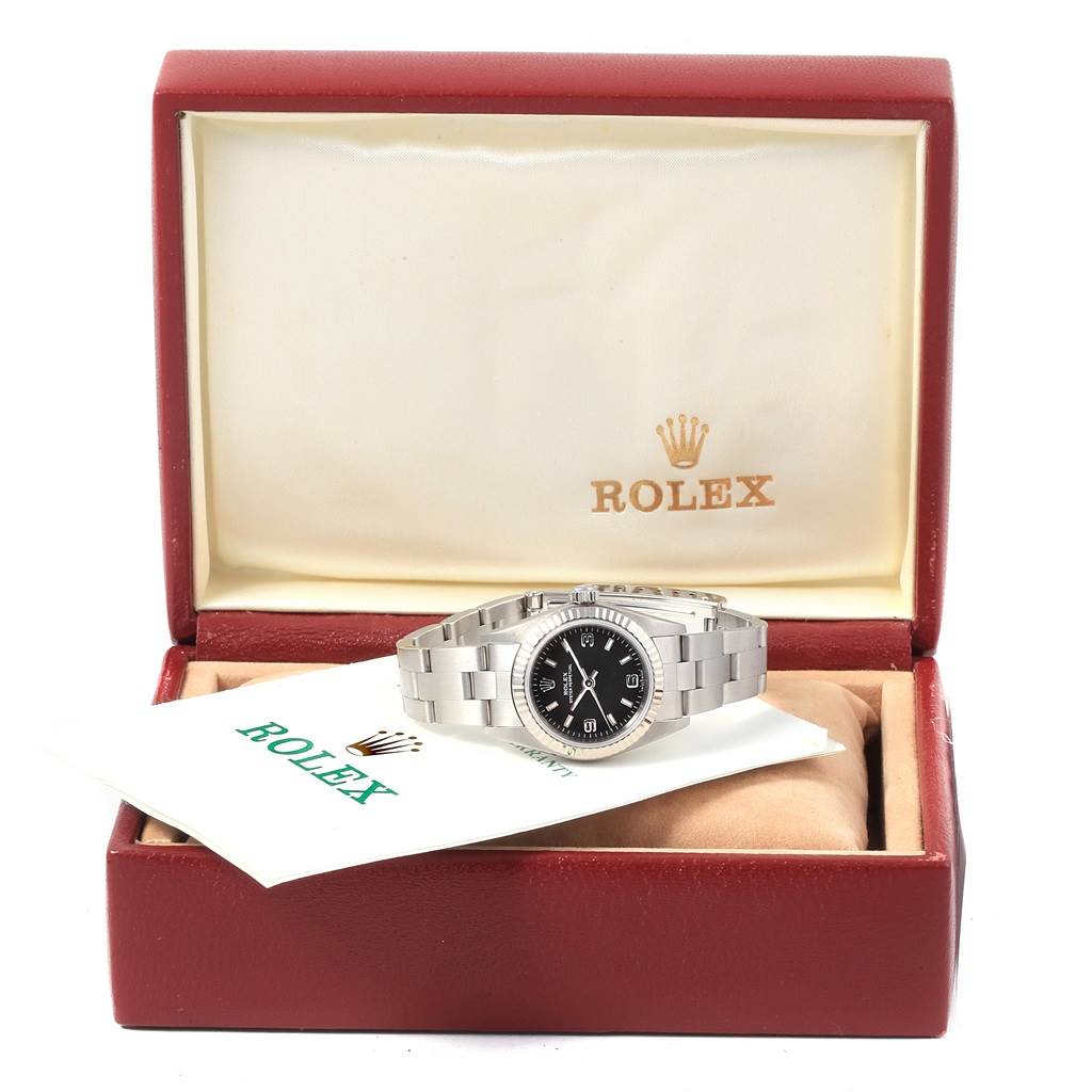 The image shows a Rolex Oyster Perpetual 76094 Women's Stainless Steel Black Dial 76094 Women's Stainless Steel Black Dial watch from the front, placed in an open Rolex box with a booklet beside it.