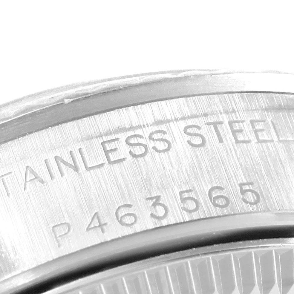 The image shows a close-up of the case back of a Rolex Oyster Perpetual 76094 Women's Stainless Steel Black Dial 76094 Women's Stainless Steel Black Dial watch, highlighting the stainless steel engraving and a serial number.