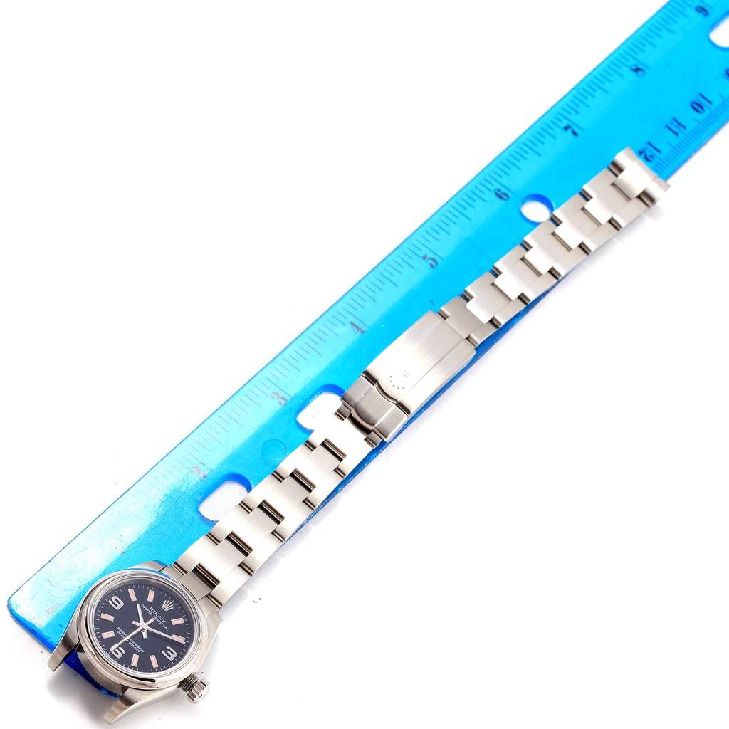 This image shows a top-down view of a Rolex Oyster Perpetual 176200 Women's Stainless Steel Black Dial 176200 Women's Stainless Steel Black Dial watch alongside a ruler for size reference.