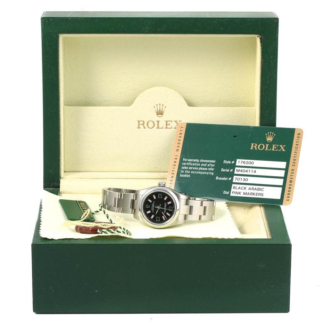 The Rolex Oyster Perpetual 176200 Women's Stainless Steel Black Dial 176200 Women's Stainless Steel Black Dial watch is shown from an angled front view inside its open box, with its warranty card and tags.
