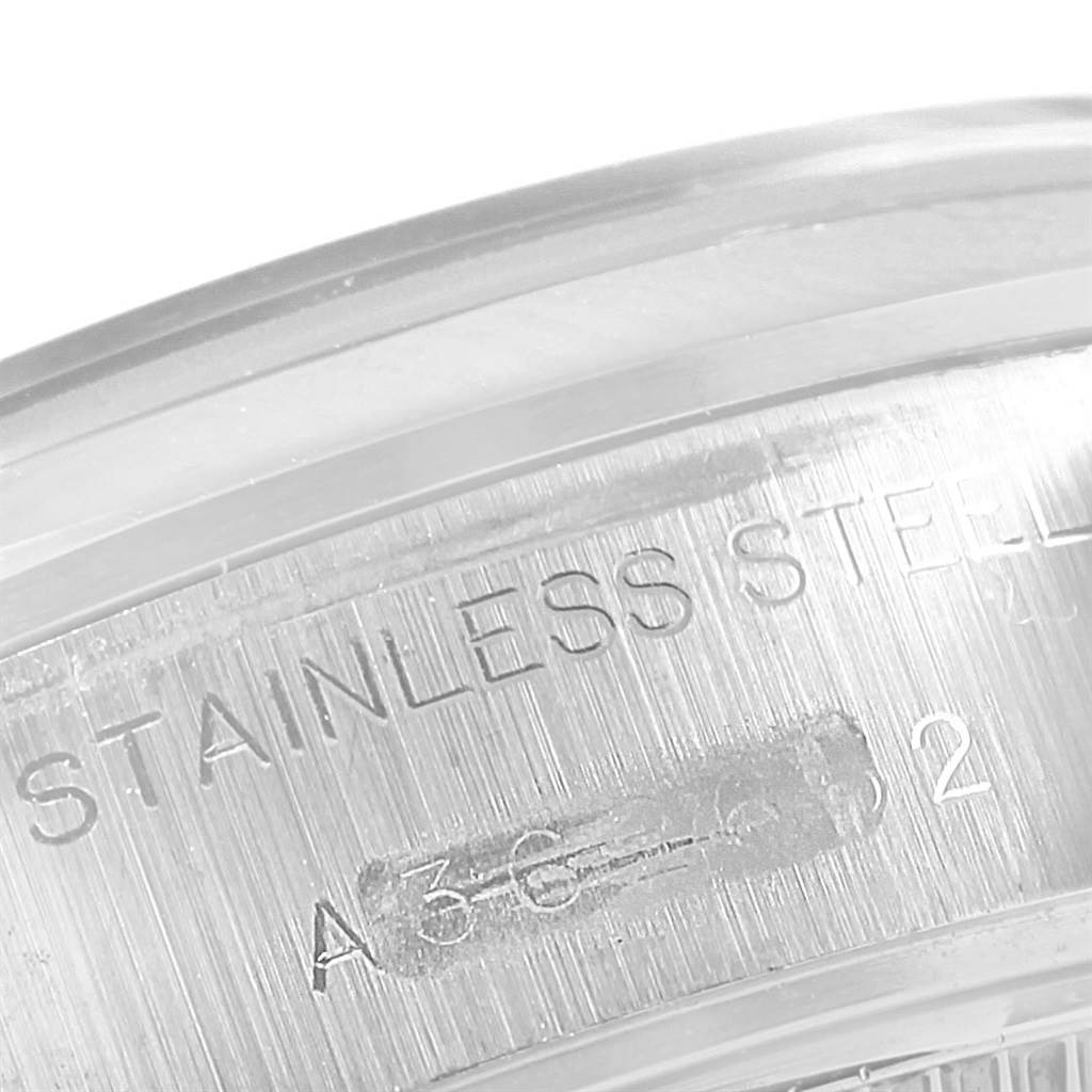 This close-up image of a Rolex Oyster Perpetual 79160 Women's Stainless Steel Blue Dial 79160 Women's Stainless Steel Blue Dial watch shows part of the stainless steel case with text inscriptions.
