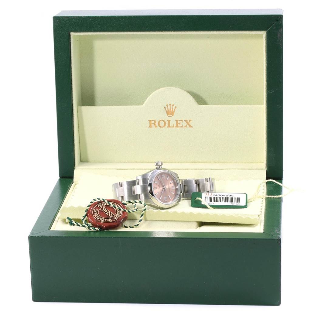 The image shows a Rolex Oyster Perpetual 176200 Women
s Stainless Steel Pink Dial 176200 Women
s Stainless Steel Pink Dial watch displayed in an open green Rolex box along with its tags.