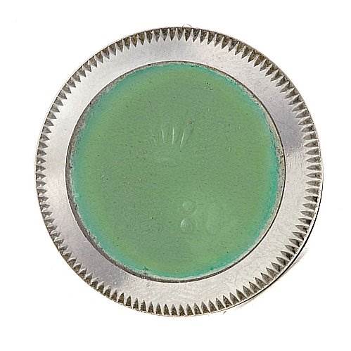 This is the rear view of a Rolex Oyster Perpetual 67180 Women's Stainless Steel Black Dial 67180 Women's Stainless Steel Black Dial watch case back, showing the ridged edges and protective green sticker.