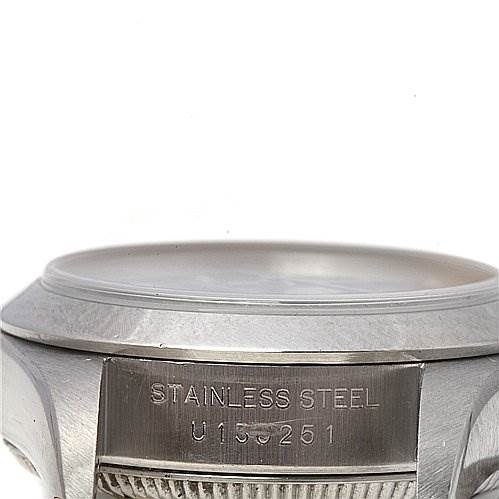 The image shows a close-up of the side of a Rolex Oyster Perpetual 67180 Women's Stainless Steel Black Dial 67180 Women's Stainless Steel Black Dial watch, highlighting the stainless steel casing and serial number.