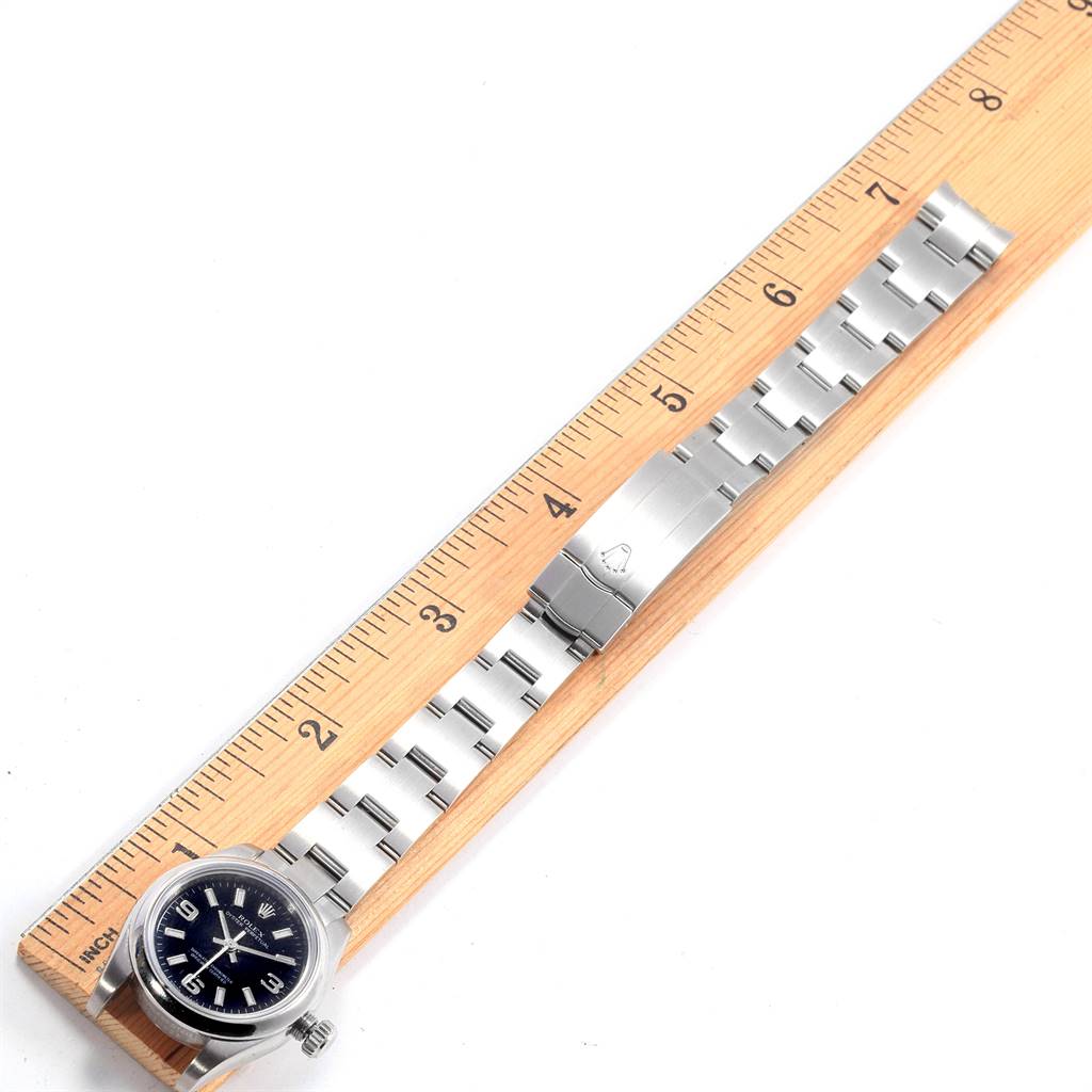 This image shows a Rolex Oyster Perpetual 176200 Women
s Stainless Steel Black Dial 176200 Women
s Stainless Steel Black Dial watch from a top-down angle, alongside a ruler.