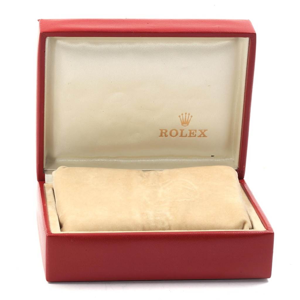 The image shows an open red Rolex box for the Oyster Perpetual model, with a beige cushion inside.
