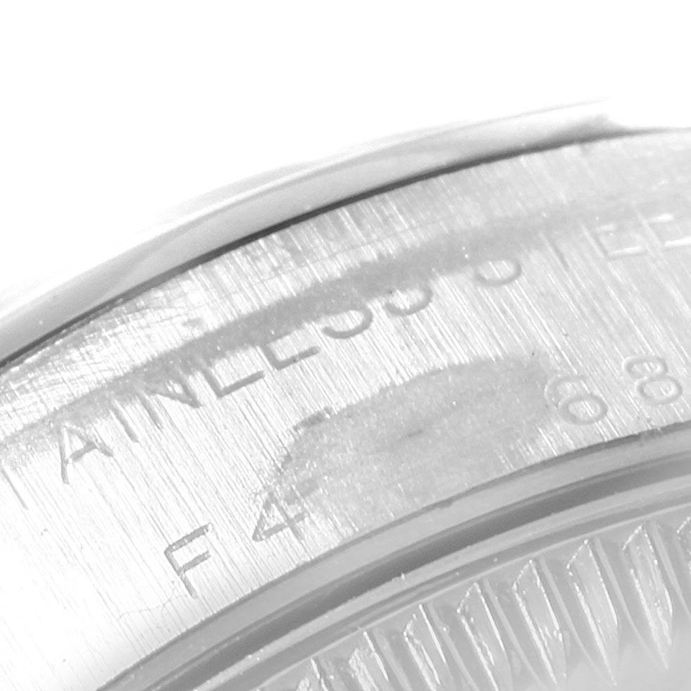 This close-up image shows a partial view of the case back of a Rolex Oyster Perpetual 76080 Women
s Stainless Steel Silver Dial 76080 Women
s Stainless Steel Silver Dial watch with engraved text.