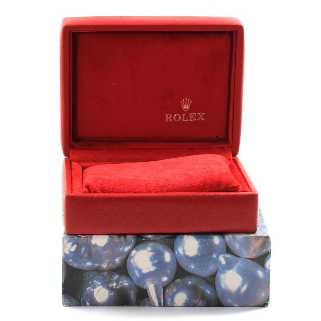 The image shows an open red Rolex Oyster Perpetual 67193 Women
s Steel and Gold (two tone) White Dial 67193 Women
s Steel and Gold (two tone) White Dial watch box, displaying the interior cushion and Rolex logo.