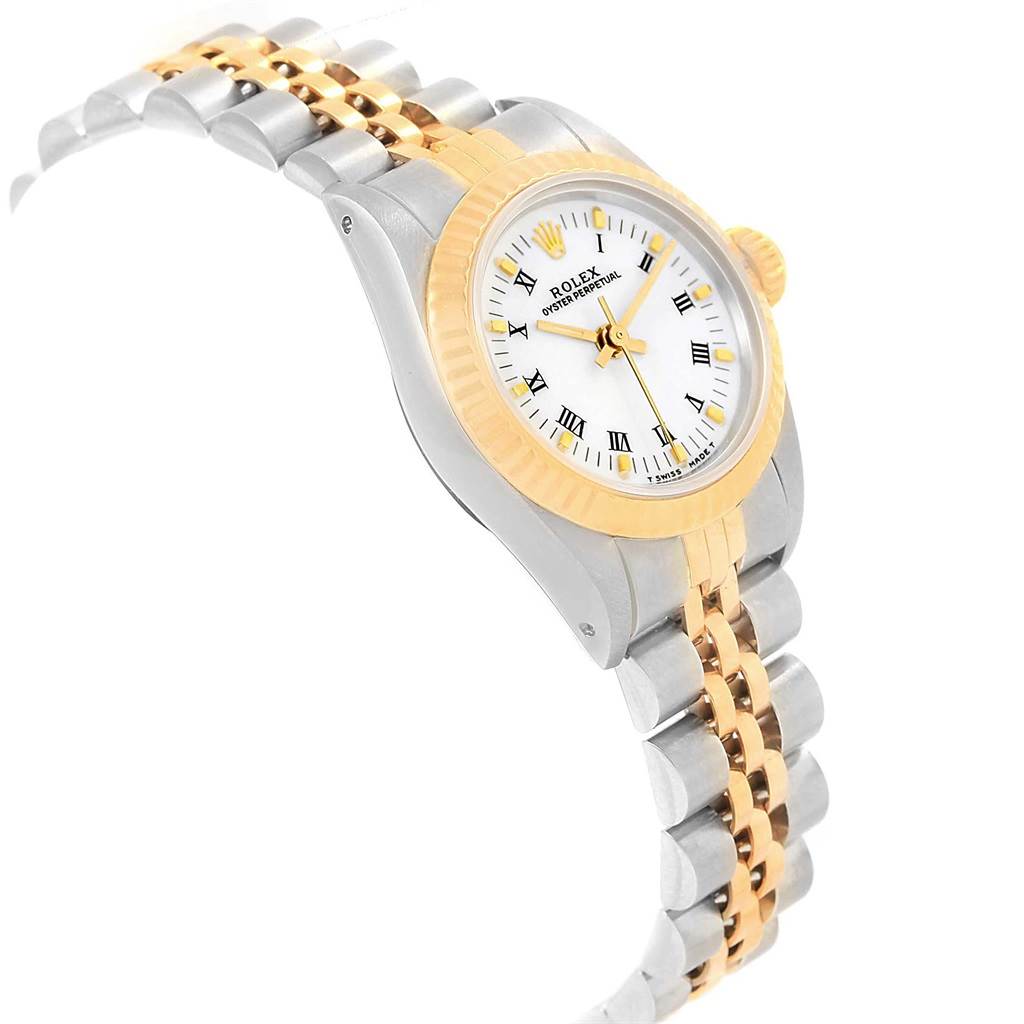 The image shows a Rolex Oyster Perpetual 67193 Women
s Steel and Gold (two tone) White Dial 67193 Women
s Steel and Gold (two tone) White Dial watch from an angled side view, highlighting the watch face, bezel, and part of the bracelet.