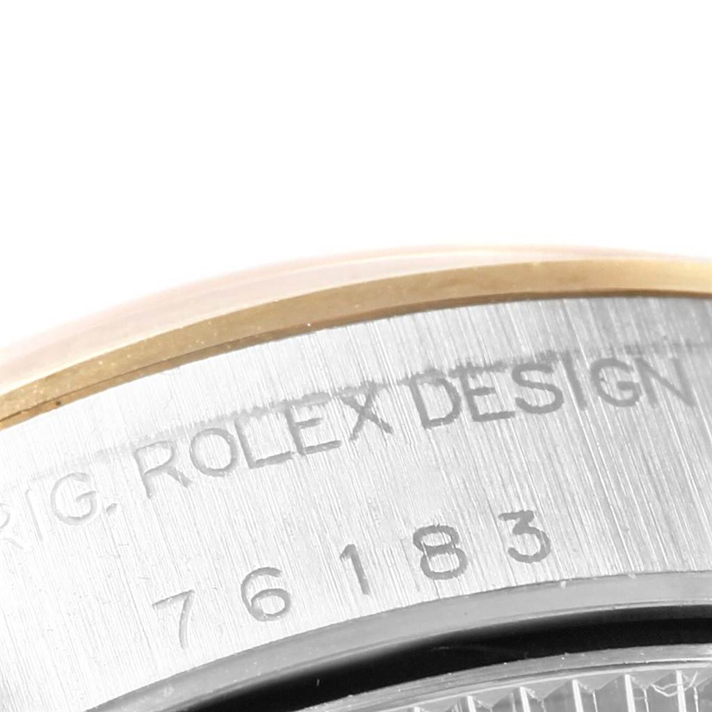 The image shows a close-up of the Oyster Perpetual Rolex watch's serial number and "ROLEX DESIGN" engraving on the case back.