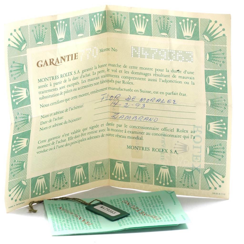 The image shows the warranty certificate and tag for the Rolex Oyster Perpetual 67180 Women's Stainless Steel White Dial 67180 Women's Stainless Steel White Dial watch, displayed at an angle.