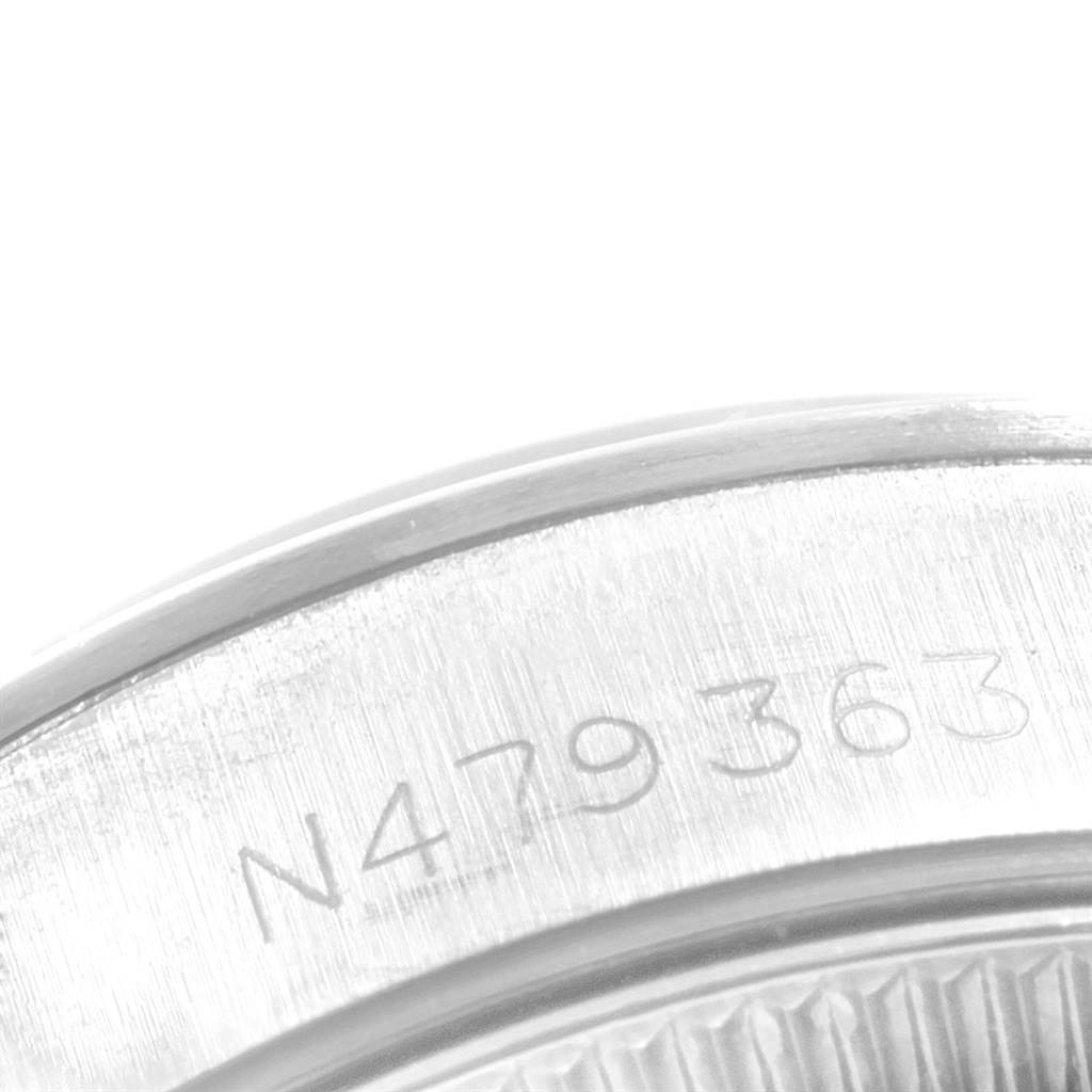 This image shows a close-up view of the edge of a Rolex Oyster Perpetual 67180 Women's Stainless Steel White Dial 67180 Women's Stainless Steel White Dial watch, highlighting the engraving with a serial number.