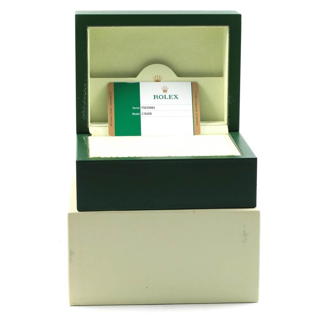 The image shows a green Rolex watch box for the Oyster Perpetual model, containing a warranty card with serial and model numbers.