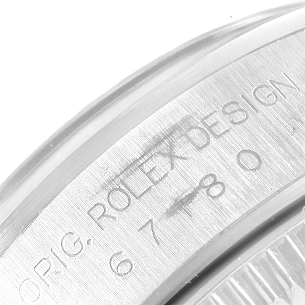 The image shows a close-up of the case back and serial number engraving on a Rolex Oyster Perpetual 67180 Women's Stainless Steel Blue Dial 67180 Women's Stainless Steel Blue Dial watch.