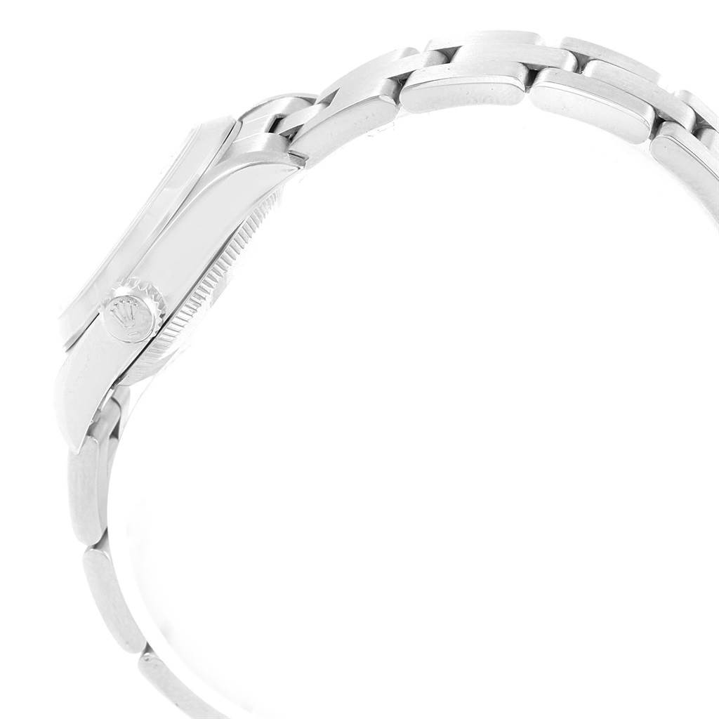 This side view of the Rolex Oyster Perpetual 67180 Women's Stainless Steel Blue Dial 67180 Women's Stainless Steel Blue Dial watch highlights its crown, case, and metal bracelet.