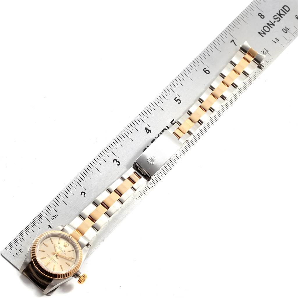 The image shows a Rolex Oyster Perpetual 67193 Women's Steel and Gold (two tone) Silver Dial 67193 Women's Steel and Gold (two tone) Silver Dial watch lying flat beside a ruler, displaying the face, bezel, and bracelet.