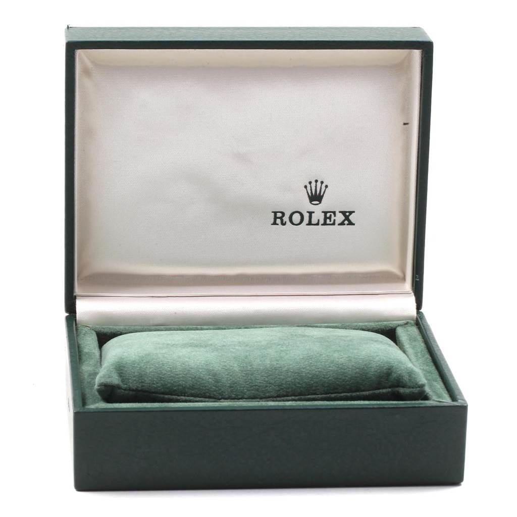 This image shows an open Rolex Oyster Perpetual 67193 Women's Steel and Gold (two tone) Silver Dial 67193 Women's Steel and Gold (two tone) Silver Dial watch box with a green cushion inside.