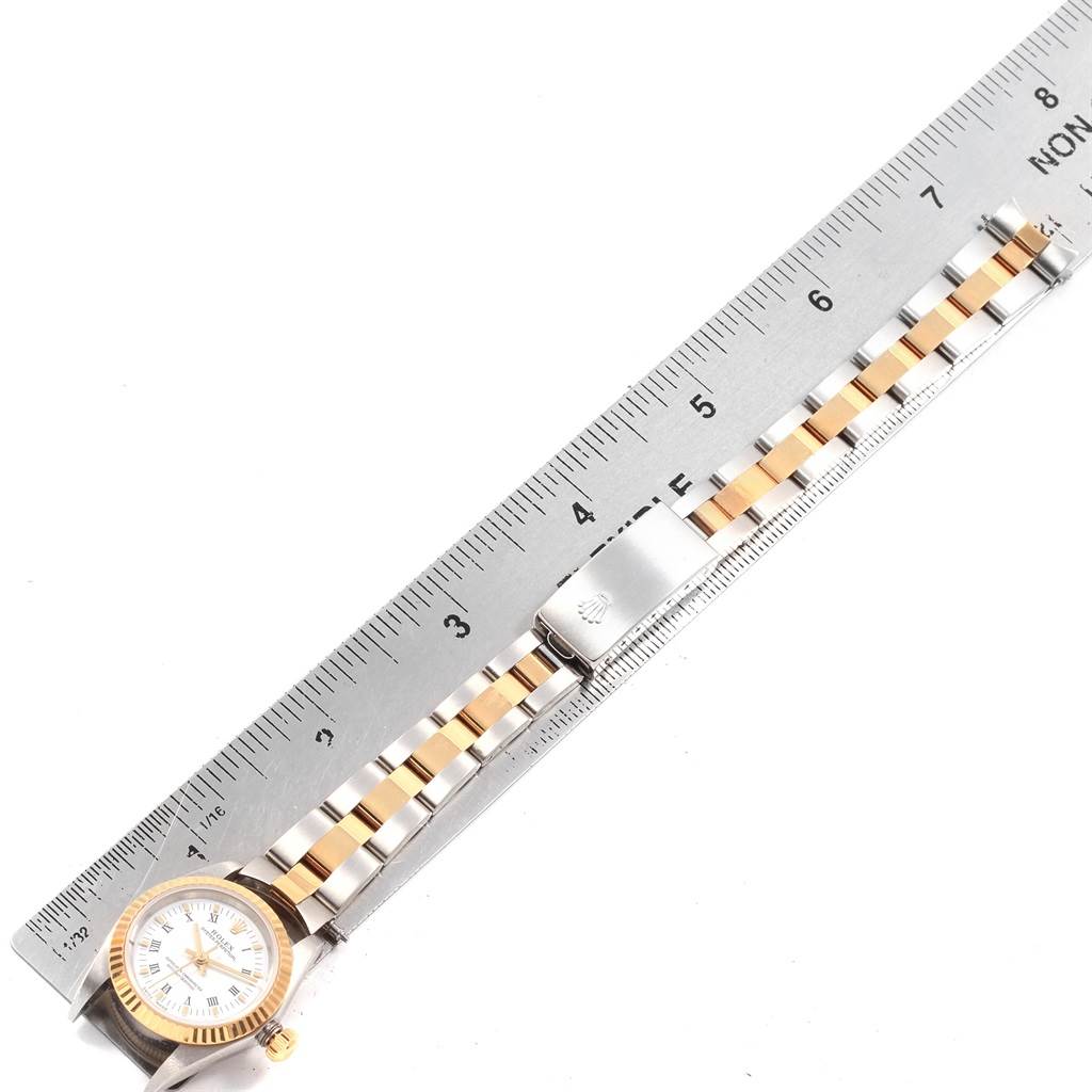 This image shows a top-down view of a Rolex Oyster Perpetual 76193 Women's Steel and Gold (two tone) White Dial 76193 Women's Steel and Gold (two tone) White Dial watch, with the wristband placed next to a ruler.