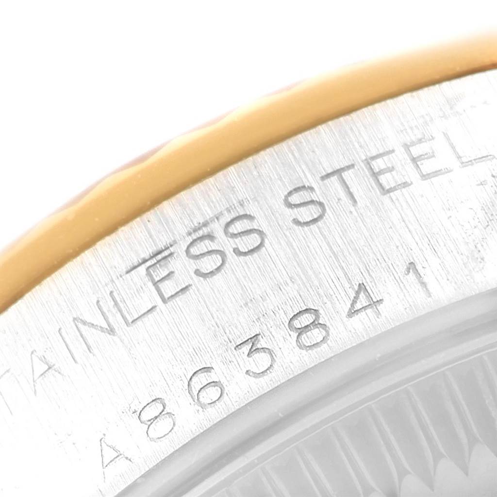 The image shows a close-up of the side engraving and part of the gold bezel of the Rolex Oyster Perpetual 76193 Women's Steel and Gold (two tone) White Dial 76193 Women's Steel and Gold (two tone) White Dial model.