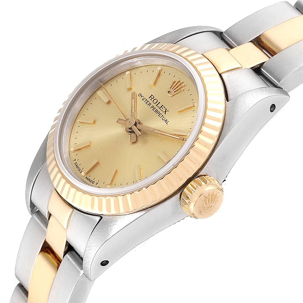 The image shows a close-up angle of the Rolex Oyster Perpetual 67193 Women
s Steel and Gold (two tone) Champagne Dial 67193 Women
s Steel and Gold (two tone) Champagne Dial watch, highlighting the dial, bezel, crown, and a part of the bracelet.