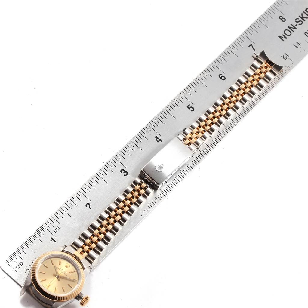 The image shows a Rolex Oyster Perpetual 67193 Women's Steel and Gold (two tone) Champagne Dial 67193 Women's Steel and Gold (two tone) Champagne Dial watch face and bracelet laid flat along a ruler for measurement.
