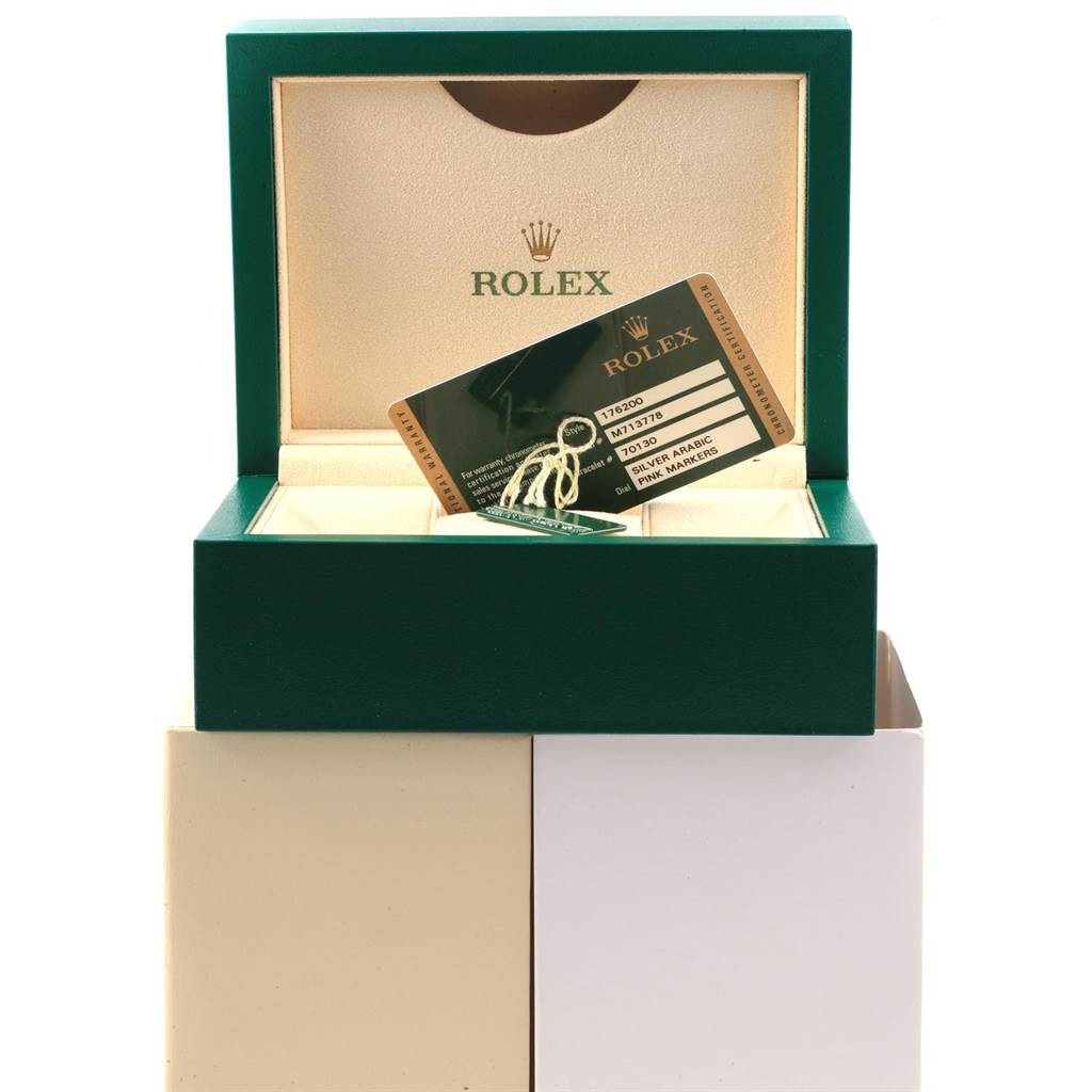 The image shows a green Rolex box for an Oyster Perpetual watch, with a guarantee card and tags inside.