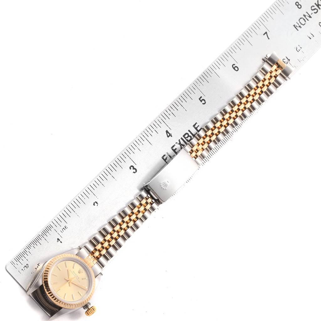 The image shows a Rolex Oyster Perpetual 67193 Women's Steel and Gold (two tone) Champagne Dial 67193 Women's Steel and Gold (two tone) Champagne Dial watch laying flat beside a ruler, highlighting the face, bezel, crown, and bracelet.