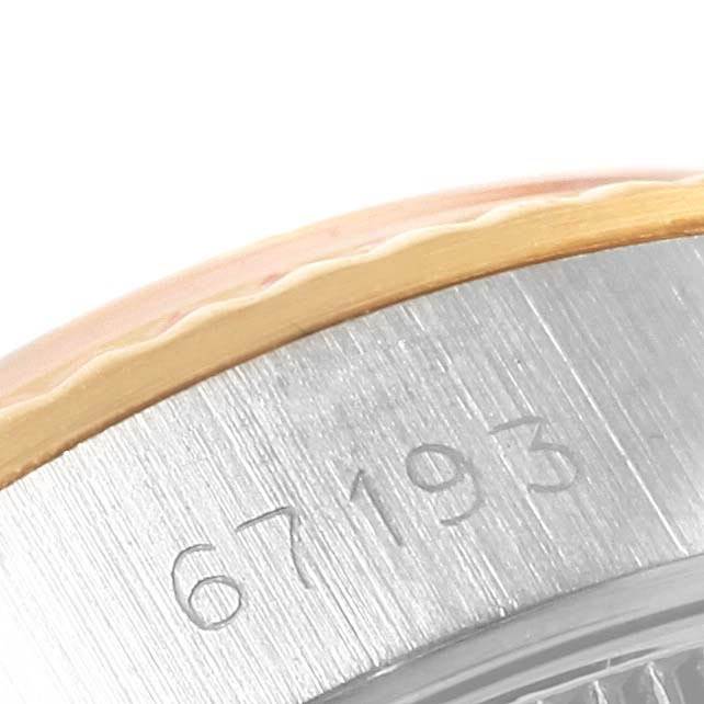 This close-up image shows the serial number engraving on the side of a Rolex Oyster Perpetual 67193 Women's Steel and Gold (two tone) White Dial 67193 Women's Steel and Gold (two tone) White Dial watch case.