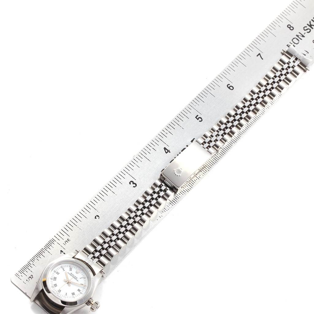 The image shows a top-view angle of a Rolex Oyster Perpetual 67180 Women's Stainless Steel White Dial 67180 Women's Stainless Steel White Dial watch and its bracelet, next to a ruler for size reference.