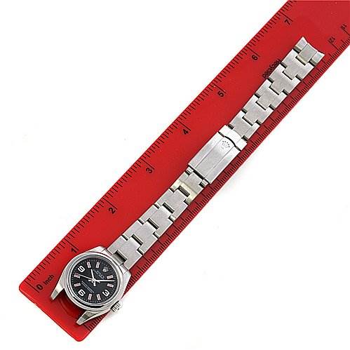 This image shows a Rolex Oyster Perpetual 176200 Women's Stainless Steel Black Dial 176200 Women's Stainless Steel Black Dial watch unfastened, placed next to a red ruler for measurement.