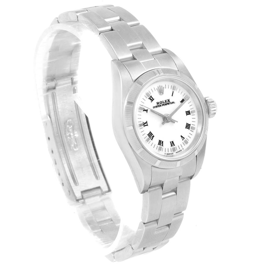 The Rolex Oyster Perpetual 67230 Women's Stainless Steel White Dial 67230 Women's Stainless Steel White Dial watch is shown at an angle highlighting the face, bezel, and bracelet with a closed clasp.